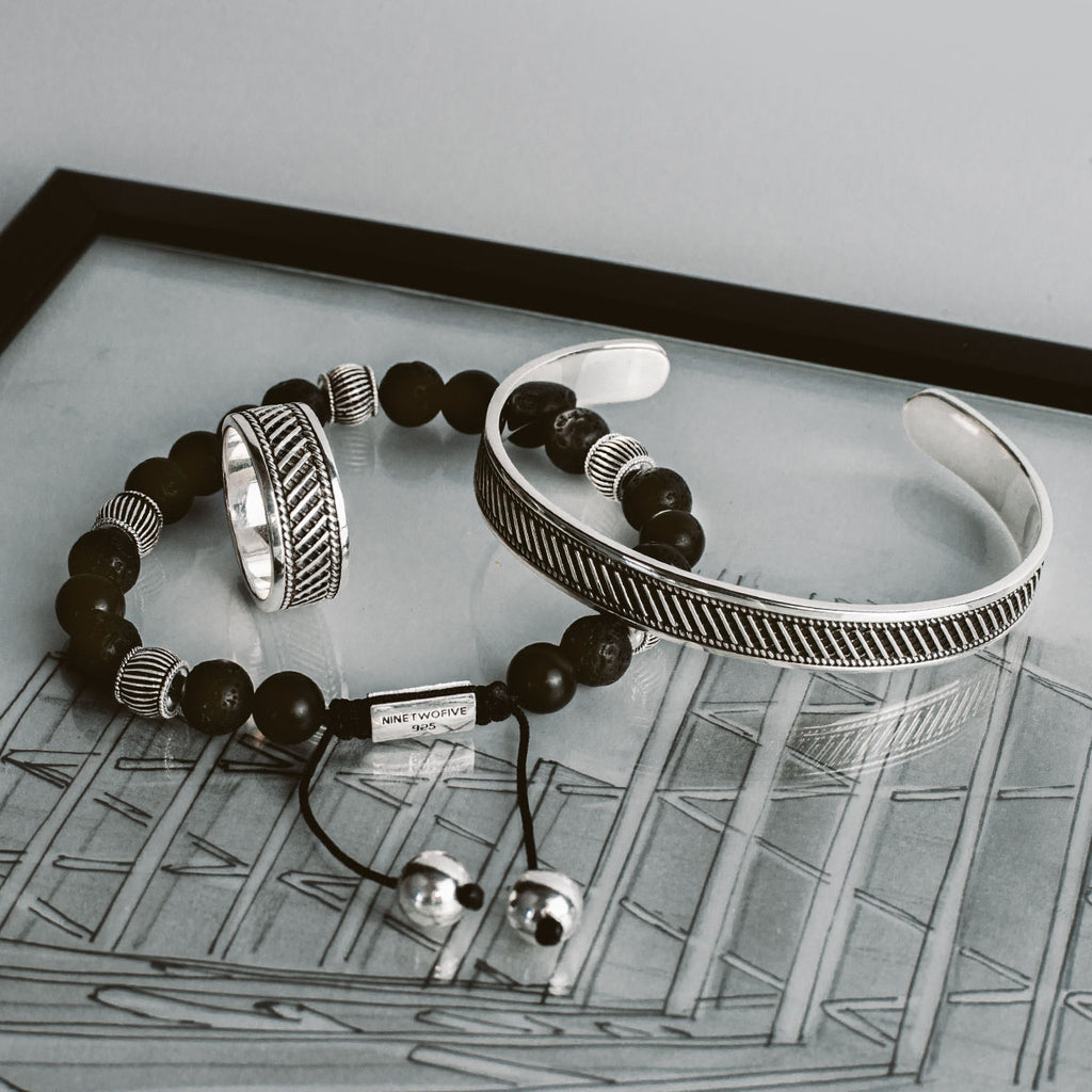 A black and silver bracelet and a pair of earrings.