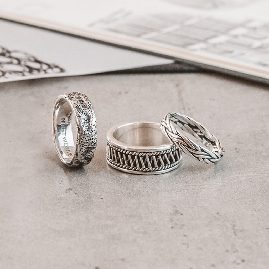 Drie zilveren ringen op een tafel.