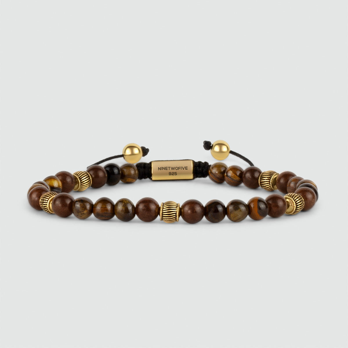 An Kaliq - Verstellbares Tigeraugen-Perlenarmband in Gold 6mm mit braunen Tigeraugen-Perlen und einer einzelnen goldenen Perle in exquisiter Handwerkskunst verziert.