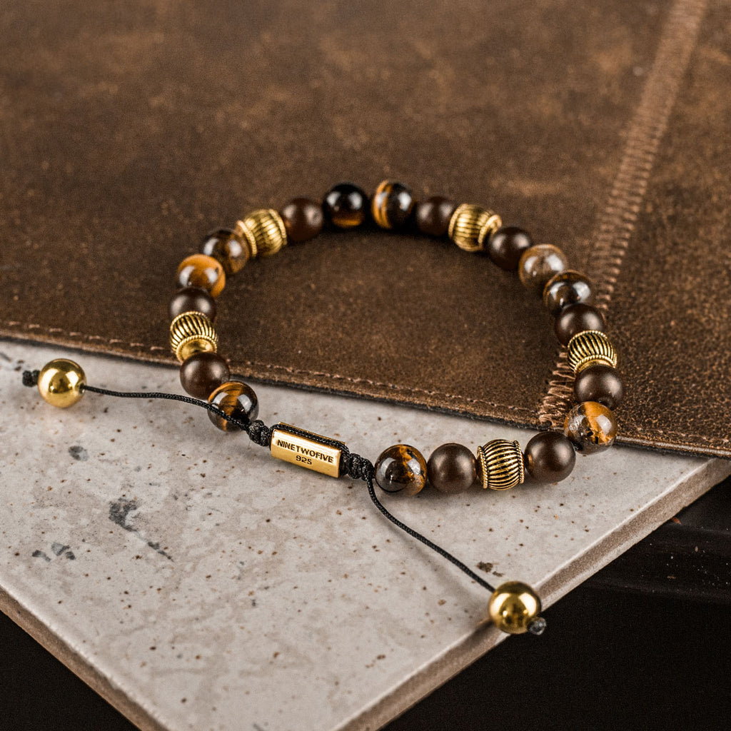 A tiger eye beaded bracelet on top of a book.