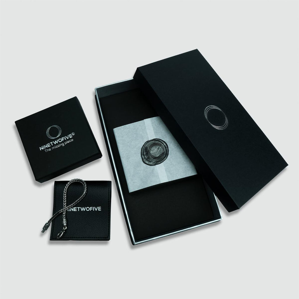 Un cadeau noir boîte avec à l'intérieur une bague Kaliq - Oxidized Sterling Silver Ring 10mm gravée pour homme.