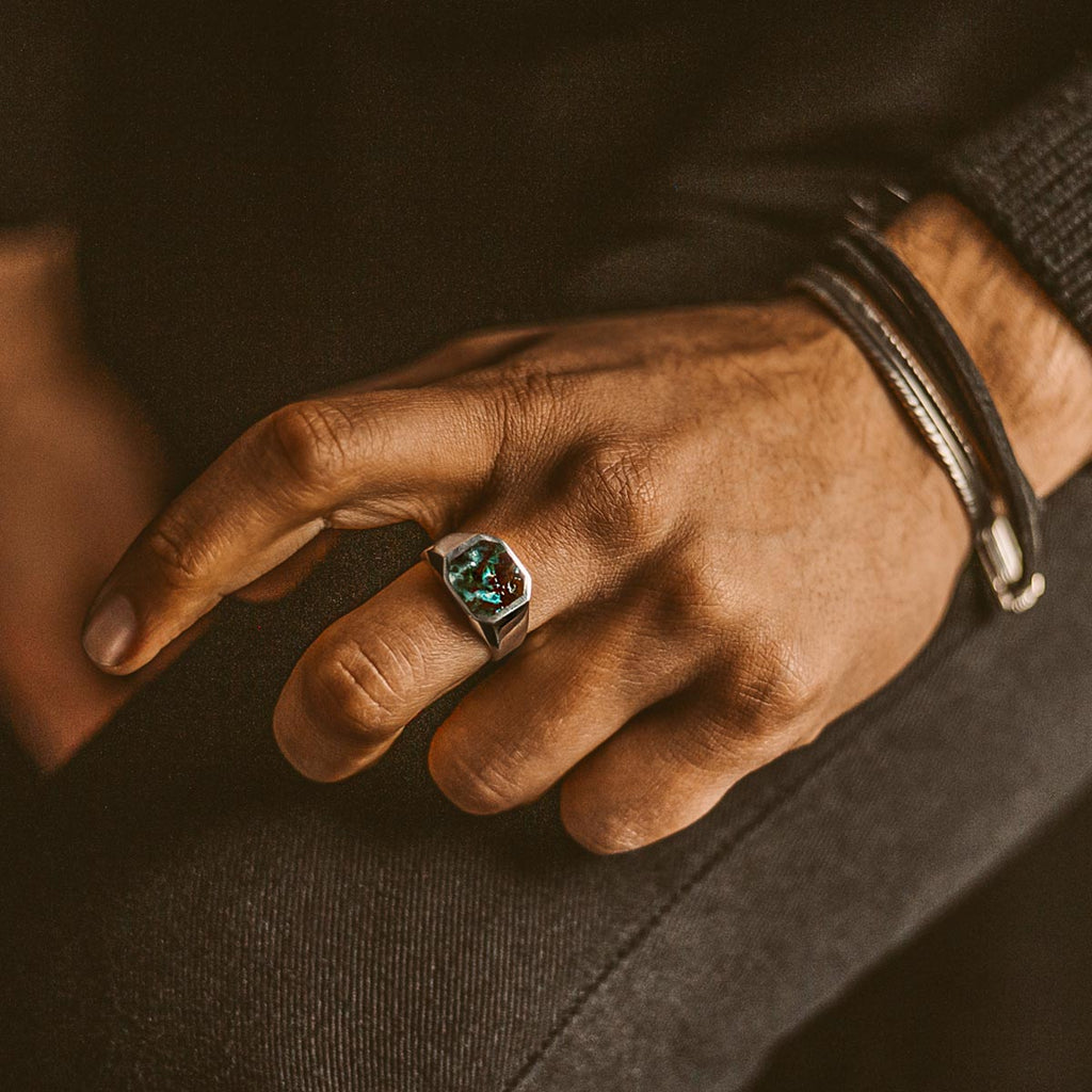 Ein Mann trägt einen Zaire - Sterling Silber Azurit Signet Ring 13mm mit einem grünen Stein.