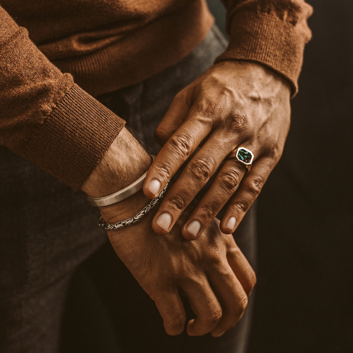 Un homme portant une bague de signet Zaïre - Azurite en argent sterling 13 mm avec une pierre émeraude.