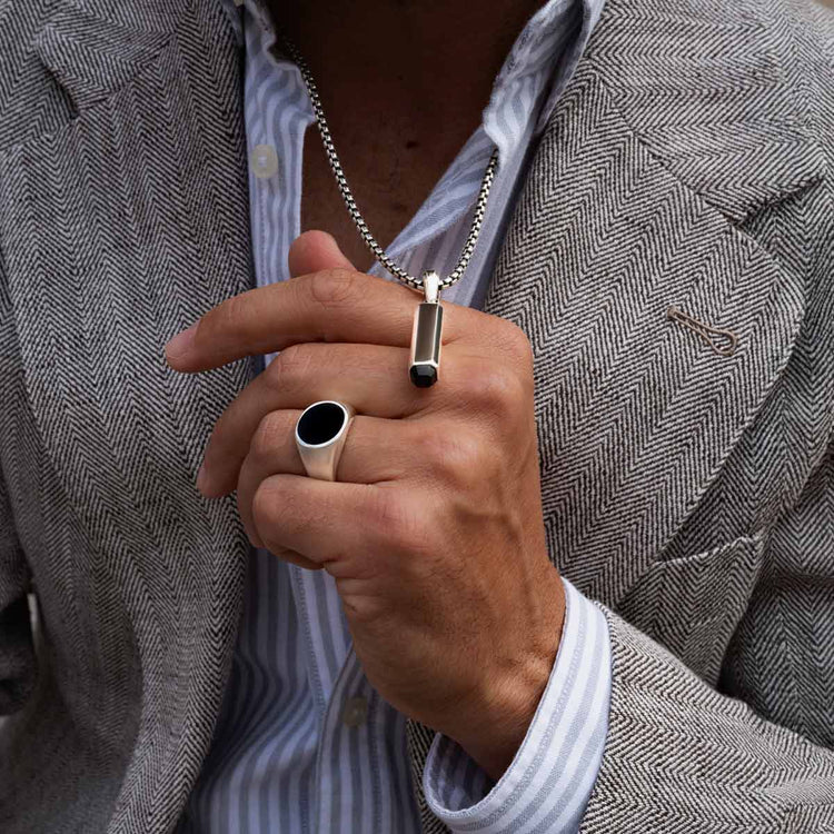 Model draagt Adil zegelring, zwarte onyx hanger en herenketting van Ninetwofive