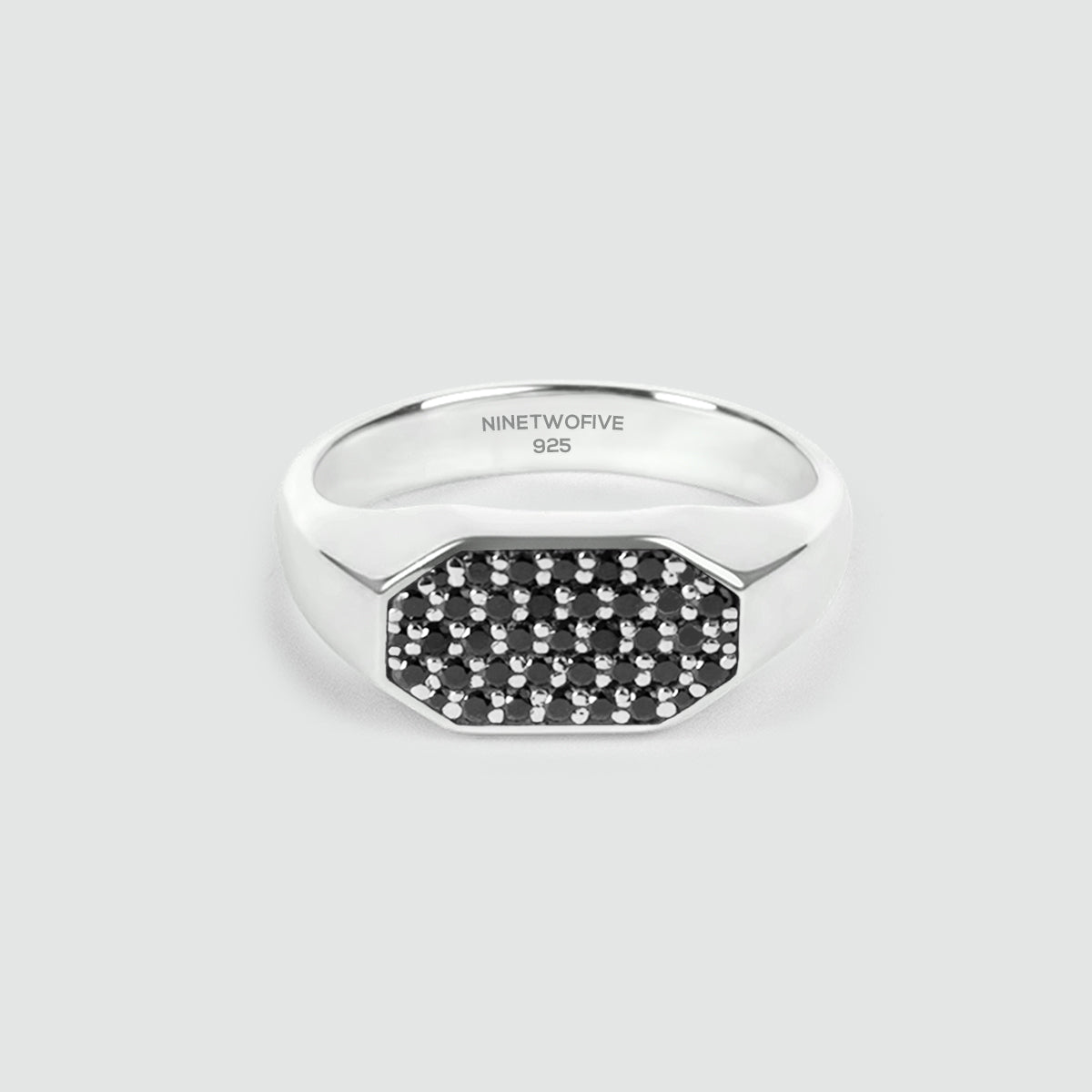 Mens silver ring with black gemstones on a light gray background