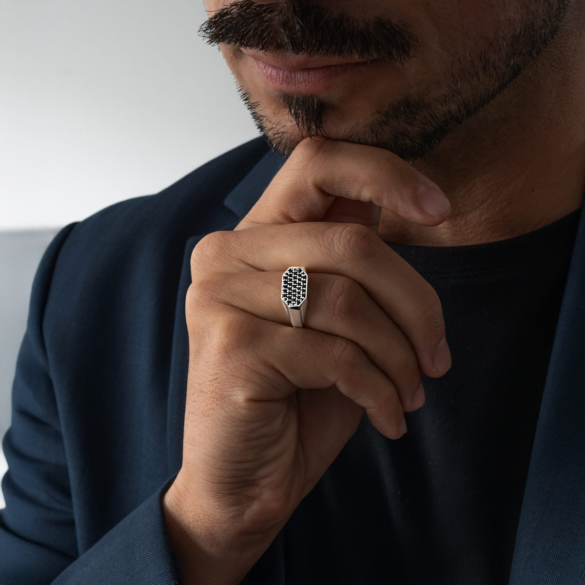 Man wearing a silver signet ring with a black diamonds, close-up of hand