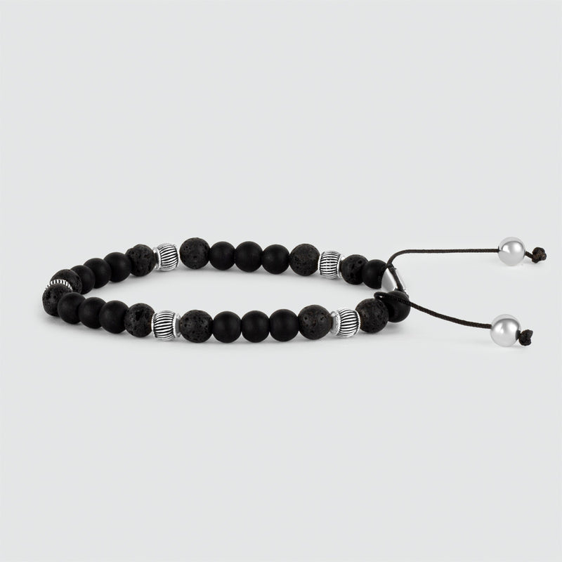 Hoekaanzicht van de Kaliq verstelbare kralenarmband in 925 zilver, versierd met zwarte onyx kralen en witte parels.