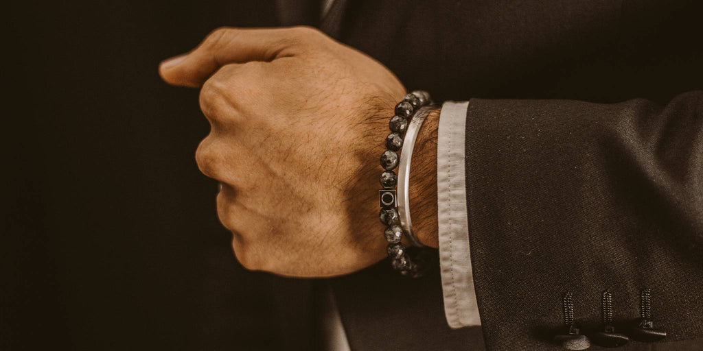 Ein Mann im Anzug trägt ein Armband.