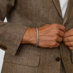 Idris - Braided Silver Bangle Bracelet 8mm, close-up detail worn with a suit