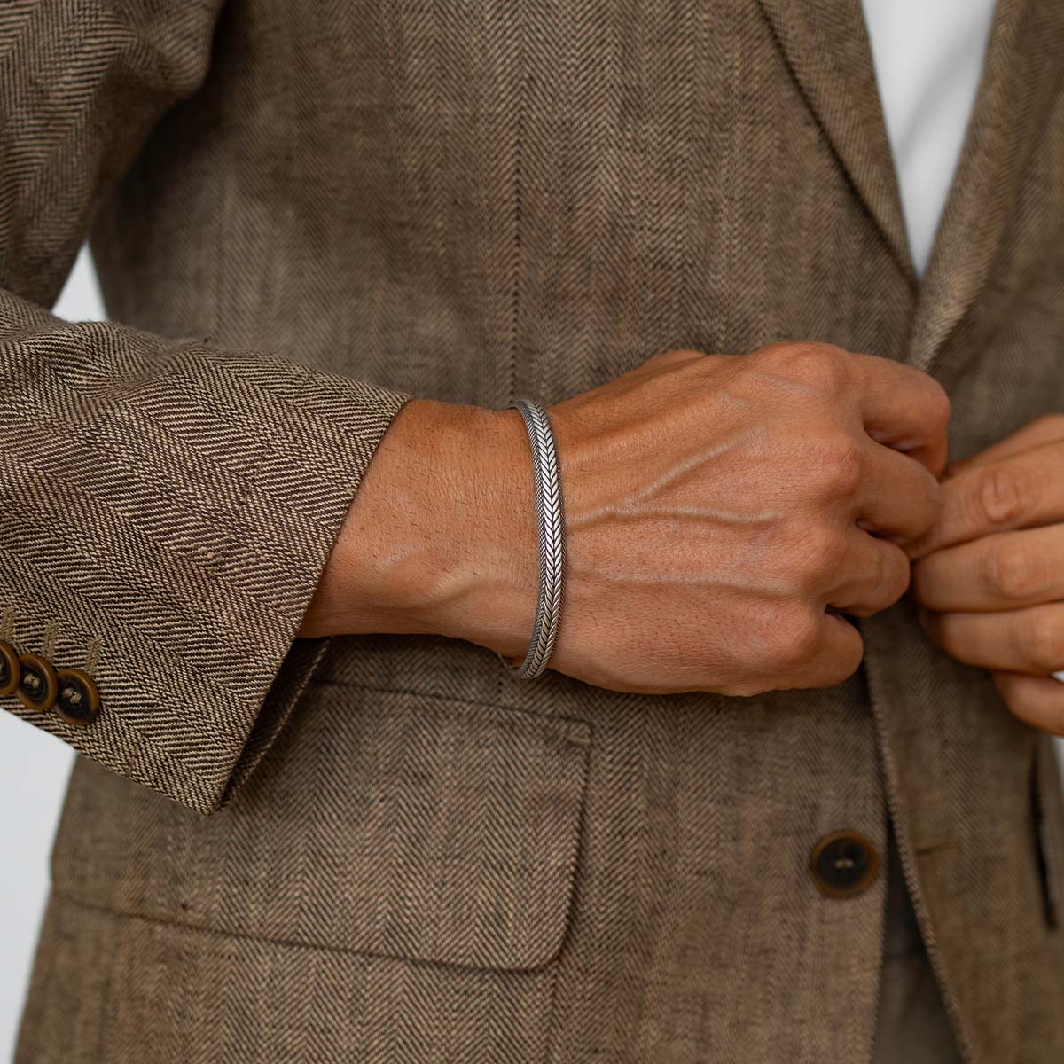 Idris - Braided Silver Bangle Bracelet 8mm, close-up detail worn with a suit