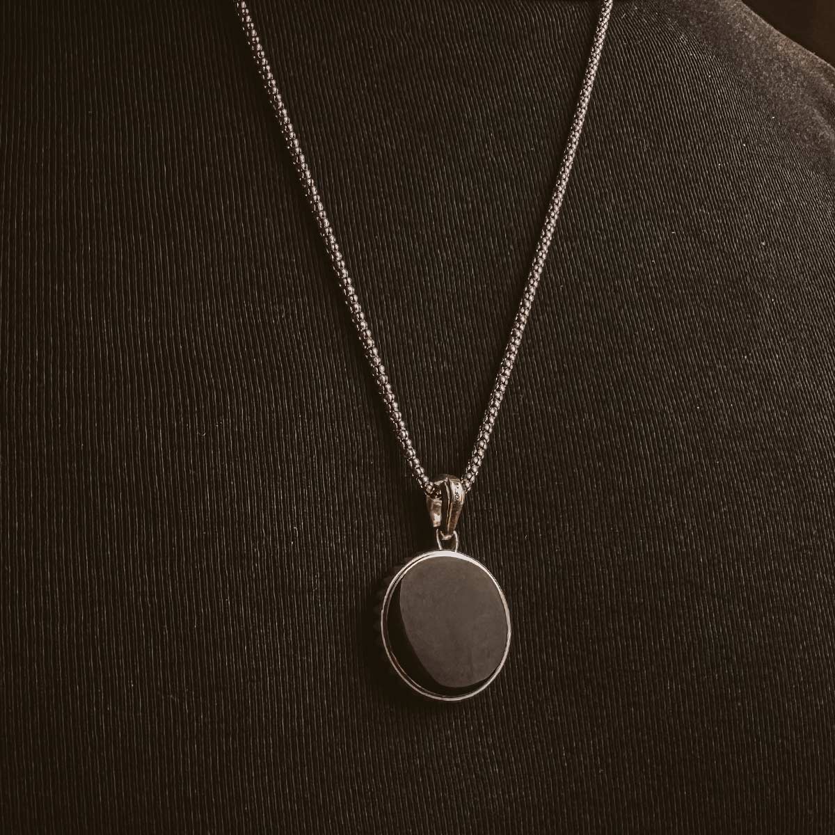 Een man draagt een Safar - Sterling Zilveren Onyx Kompas Hanger ketting.