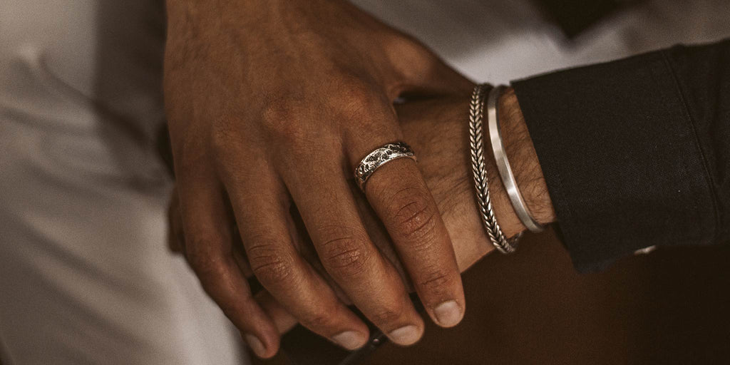 Ein Mann hält einen Ring an seiner Hand.