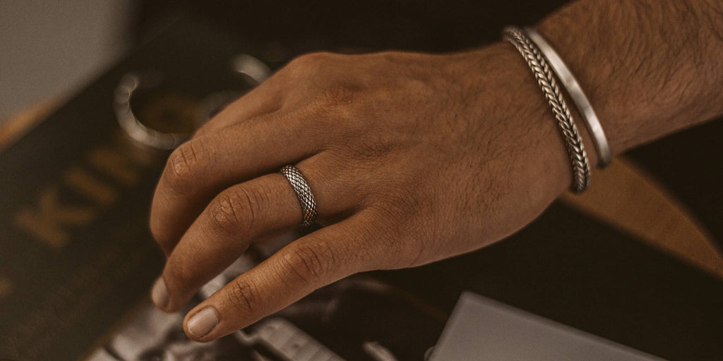 Een hand met een zilveren ring.
