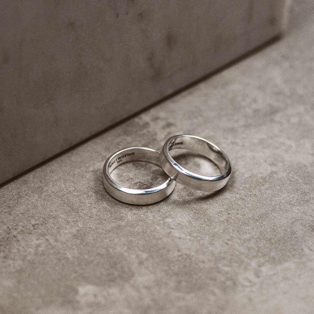 Two silver wedding rings on a surface.