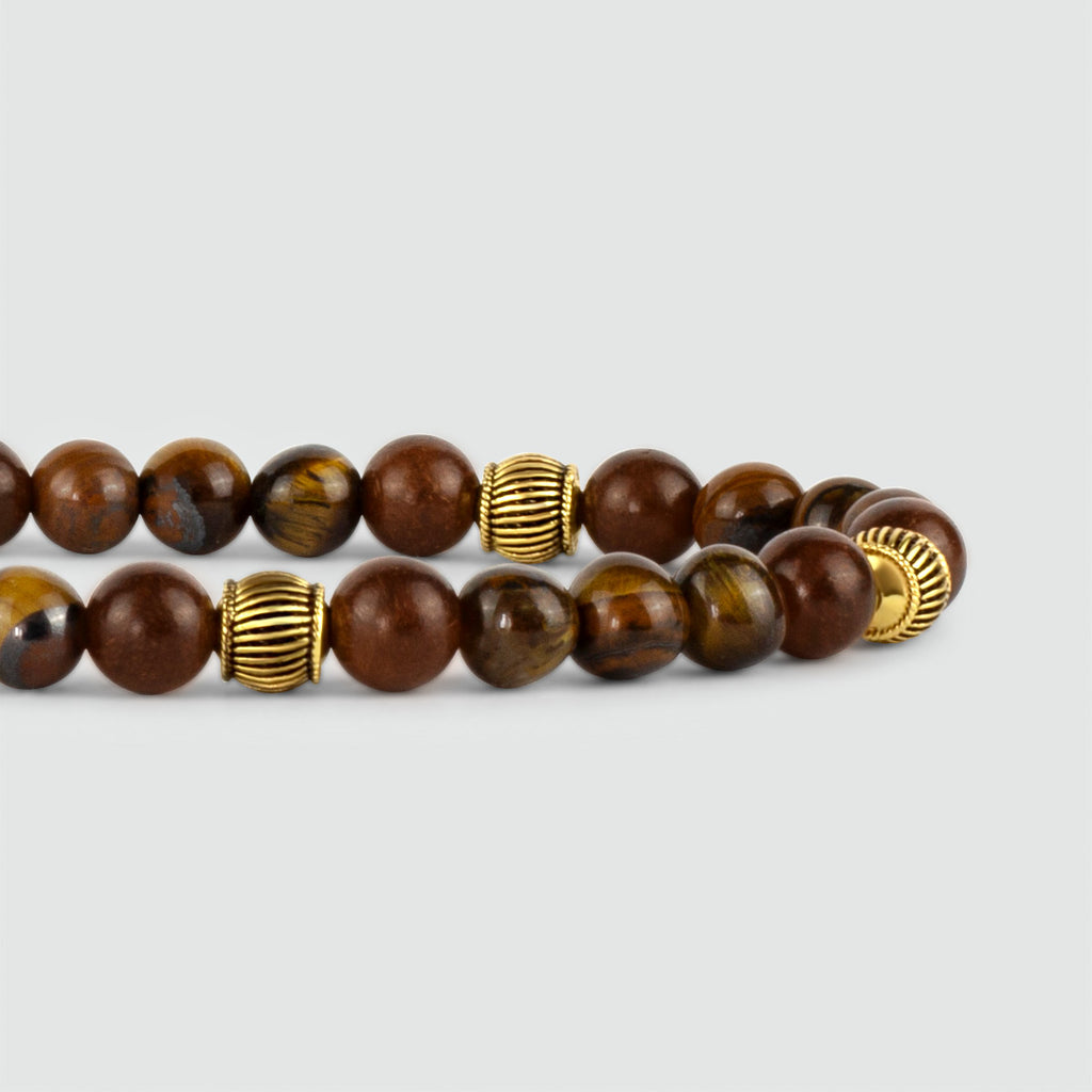 A Kaliq - Adjustable Tiger Eye Beaded Bracelet in Gold 6mm with gold accents.