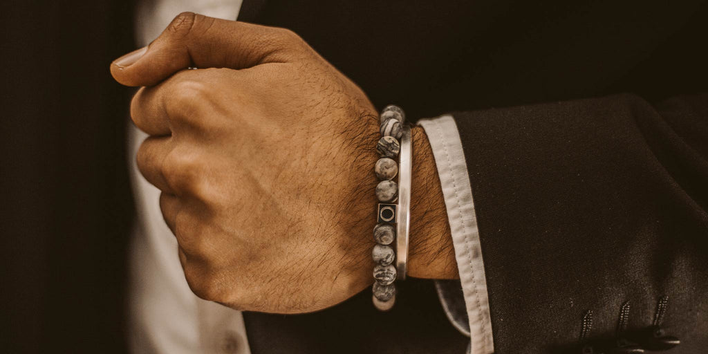 A man in a suit is wearing a bracelet.