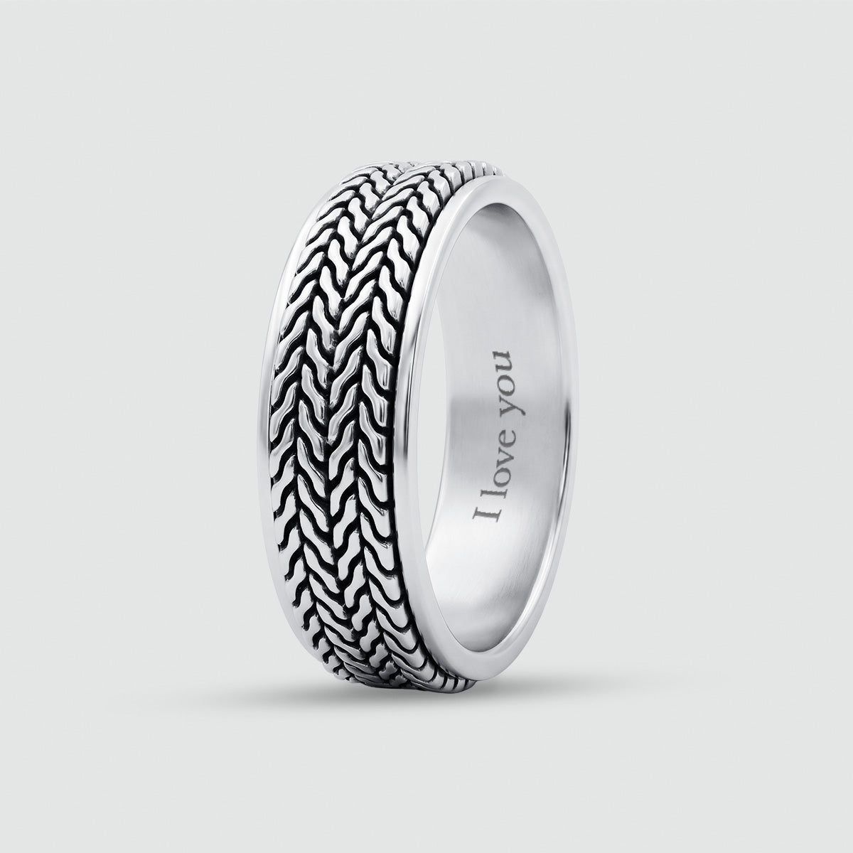 A silver band ring featuring a textured, woven outer pattern and a smooth, polished inner band engraved with the words 'I love you', shown on a light gray background.