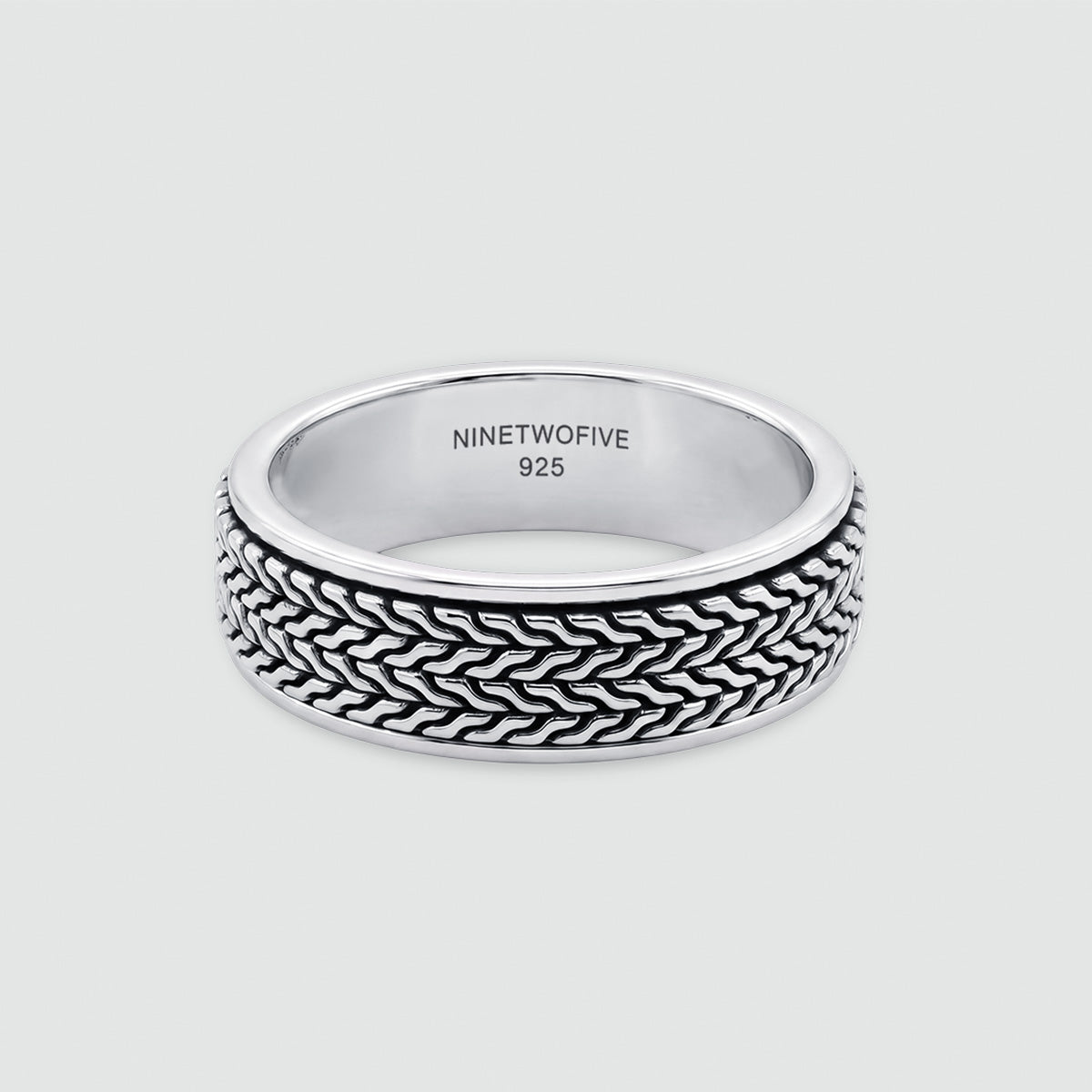A sterling silver ring with a textured, woven basket-like pattern on the outer band, shown on a light gray background. The inside of the band is engraved with 'NINETWOOFIVE 925'.
