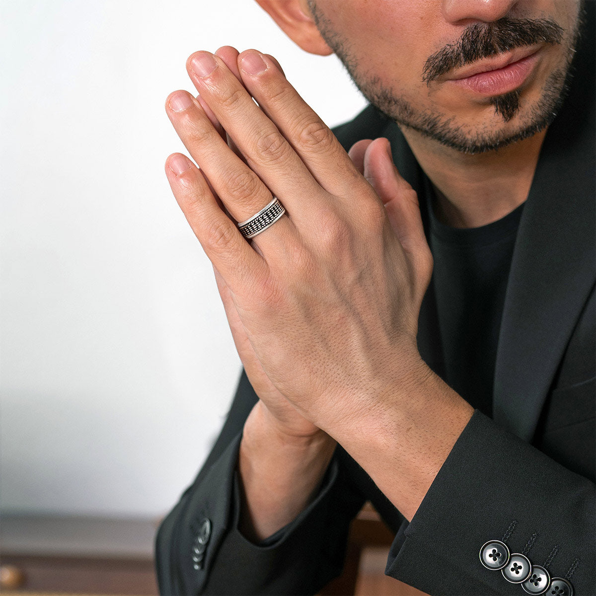 Man in black suit wearing Ninetwofive hidan sterling silver spinner ring on his ring finger. 