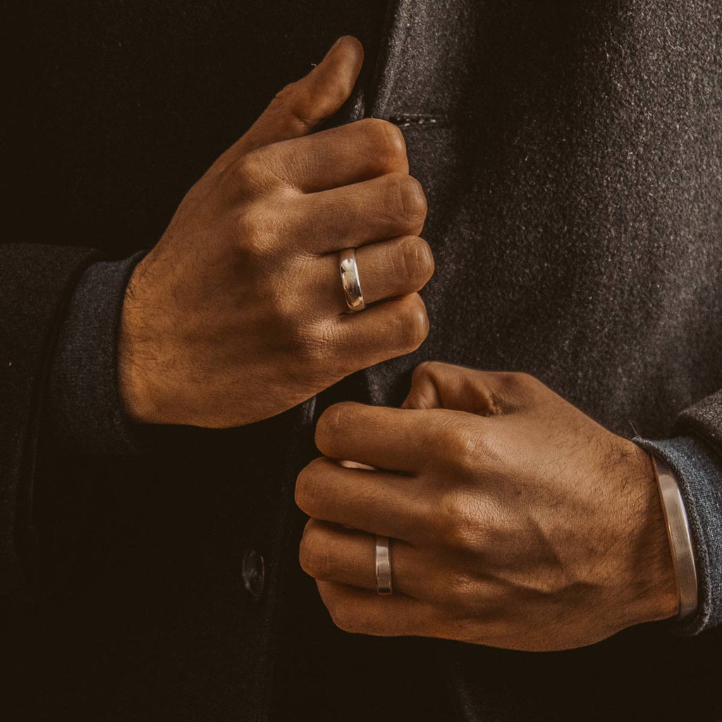 Ein Mann im Anzug steckt sich einen Ehering an.
