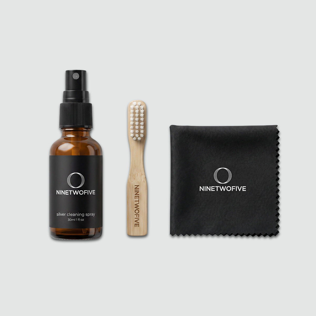 Ninetwofive met spuitfles, borstel en doekje op een lichtgrijze achtergrond