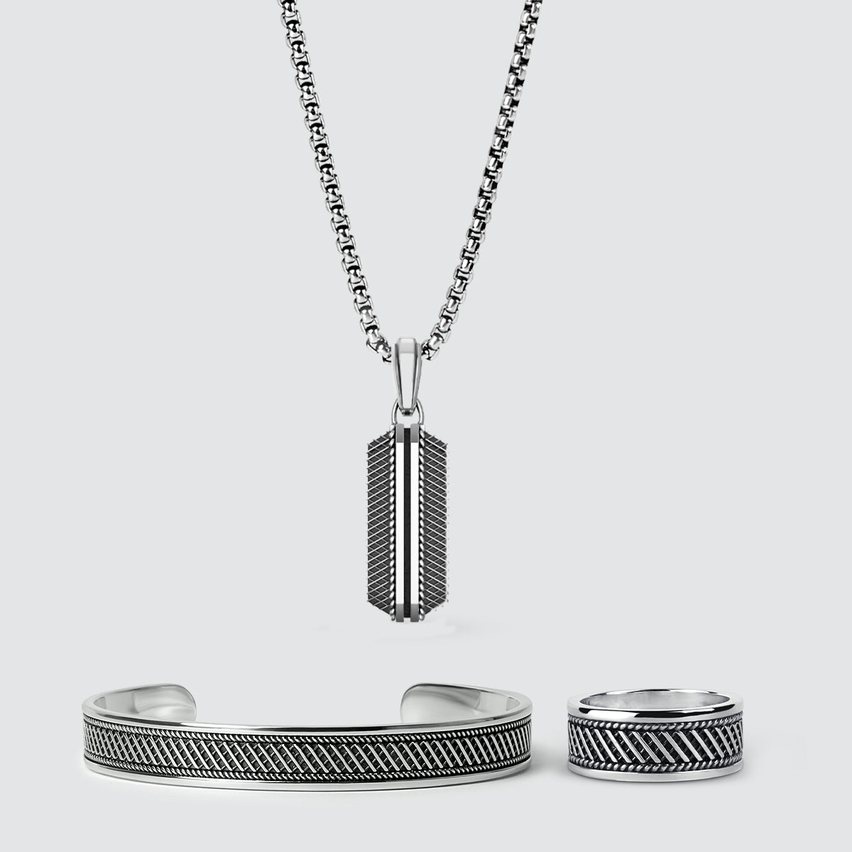 Vooraanzicht van Kaliq geoxideerd zilveren hanger, herenring en bangle van Ninetwofive sieraden.