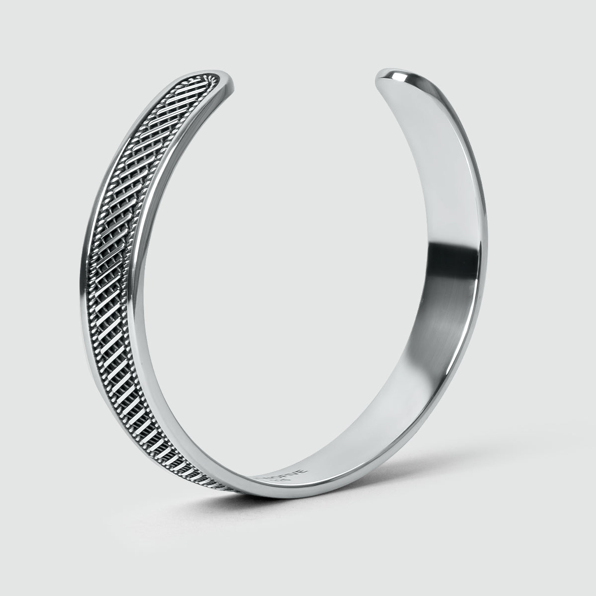 Zijaanzicht van Kaliq geoxideerde sterling zilveren armband met een geweven patroon. Ninetwofive.