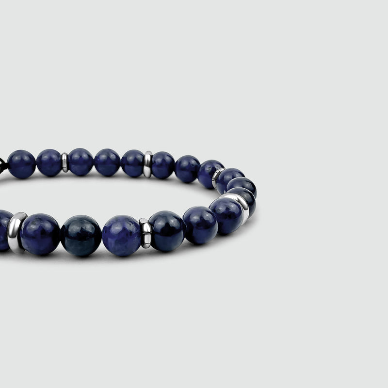 Close up side view of Kadar mens dark blue bracelet by Ninetwofive on a white surface.