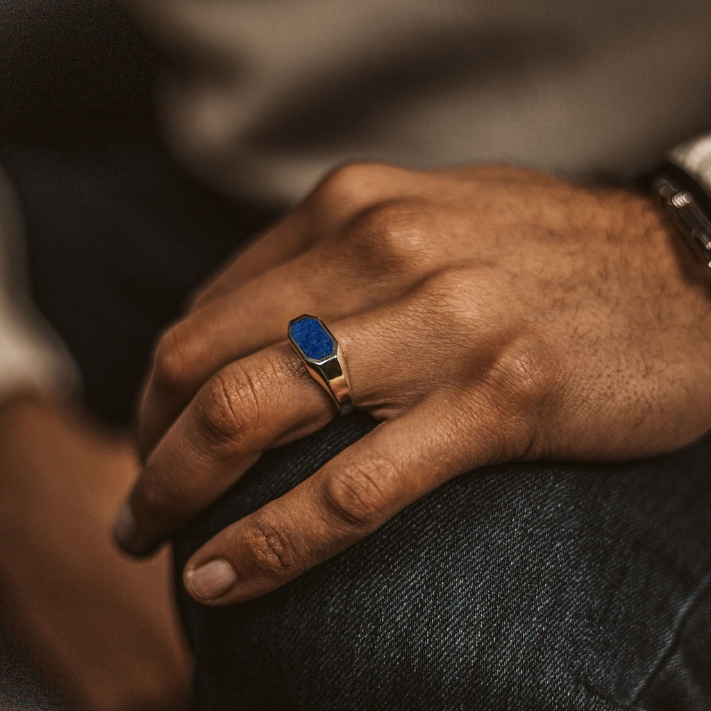 Ein Mann trägt den Rafiq - Eleganter Lapislazuli Siegelring 7 mm mit einem blauen Saphir.