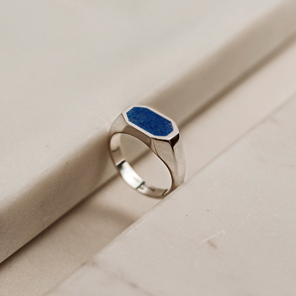 A silver ring with a blue stone.