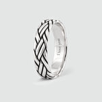 Latif braided ring standing upright, with a personal engraving inside the band