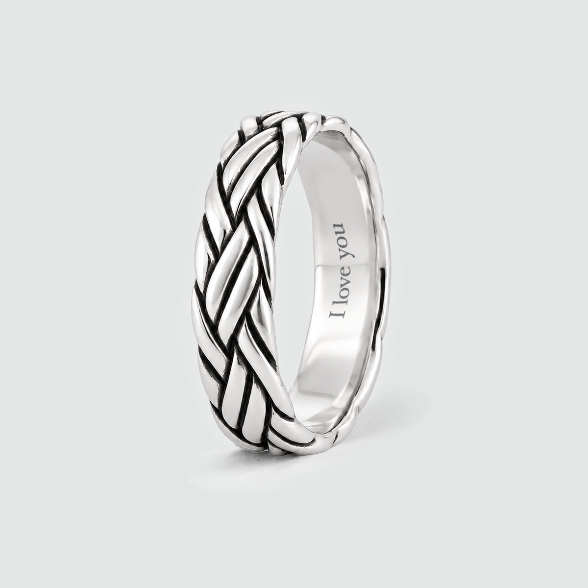 Latif braided ring standing upright, with a personal engraving inside the band