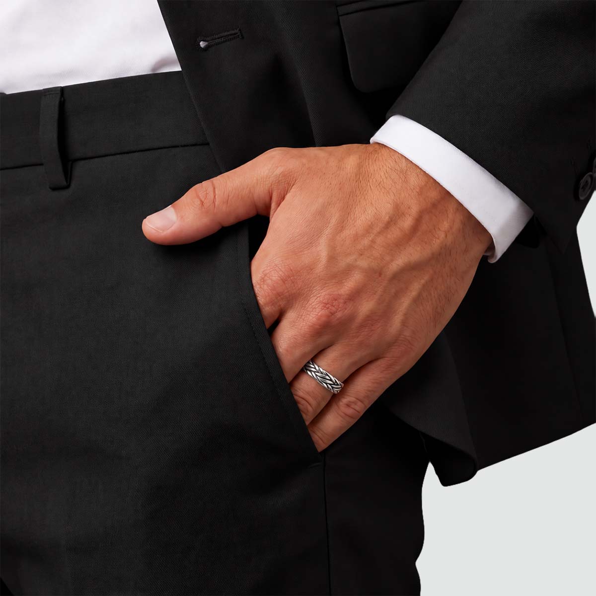 Latif silver braided ring worn with a black suit, hand in trouser pocket