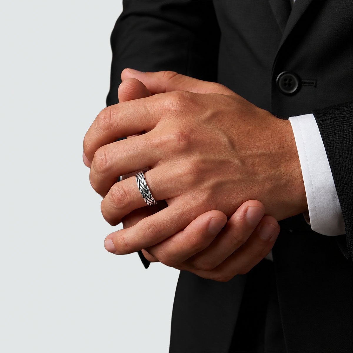 Man with clasped hands wearing the Latif woven sterling silver ring