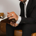 Model wearing matt finish silver ring and Hayel men’s cufflinks from Ninetwofive while reading a book.