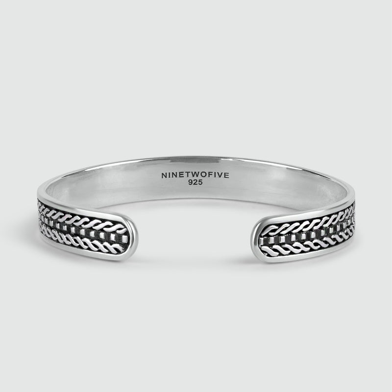 Een gepersonaliseerde Fariq geoxideerde 925 sterling zilveren armband met gevlochten design, met aan de binnenzijde gegraveerde 925 keurmerken.