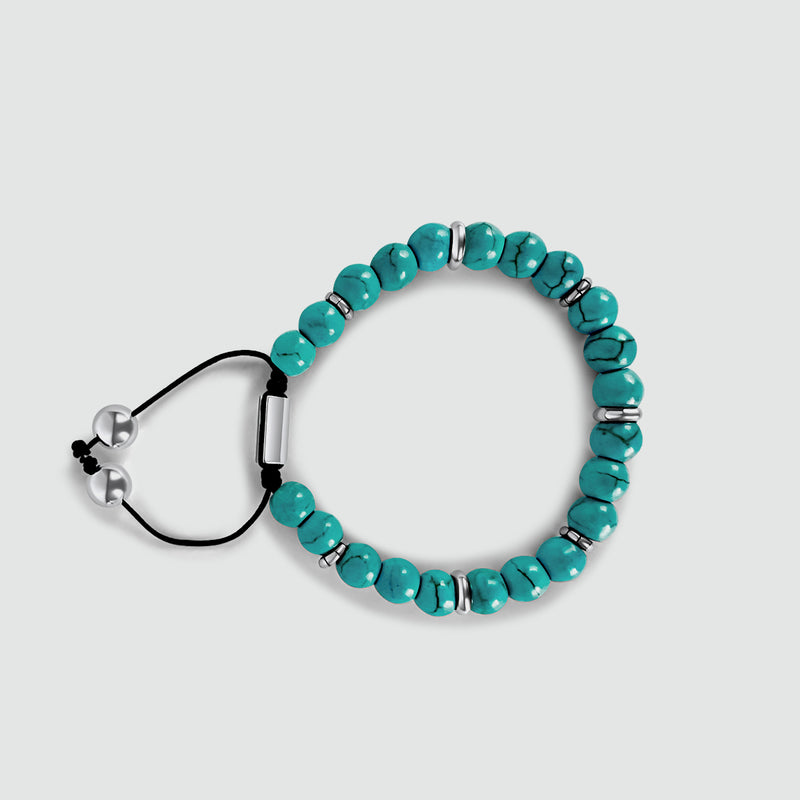 Bovenaanzicht van de Nuri heren kralenarmband met natuurlijke turkoois en sterling zilveren kralen, op een witte achtergrond.
