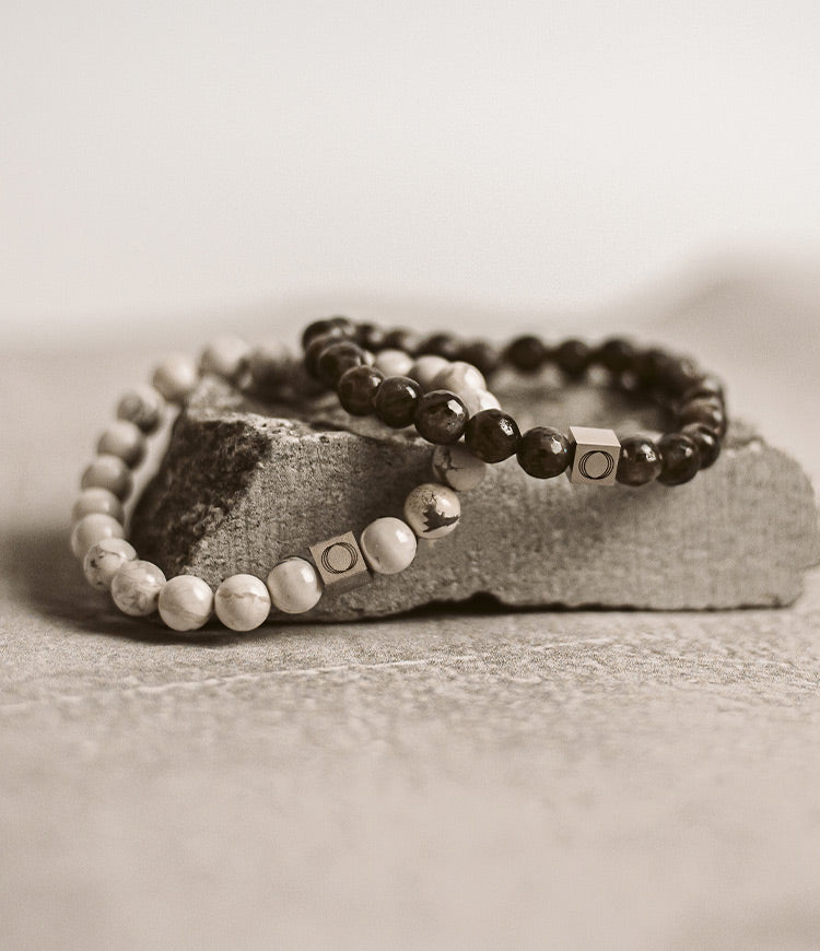 Two black and white bracelets on a rock.