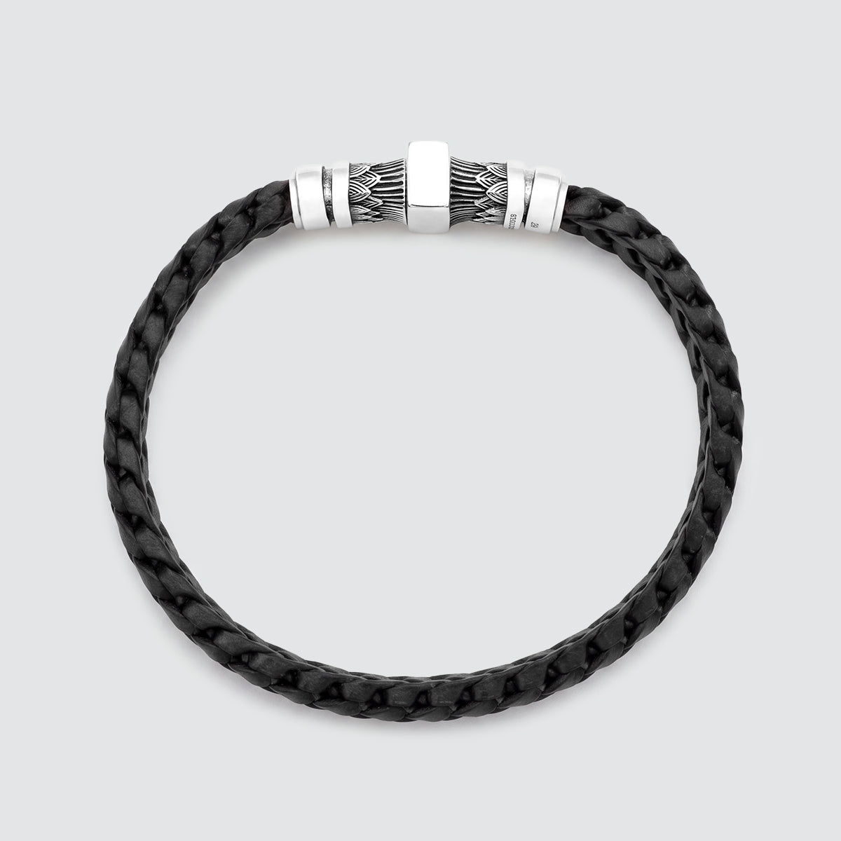 A black braided leather bracelet with a silver-toned metal clasp featuring a central square plate and textured side details, shown on a light gray background.