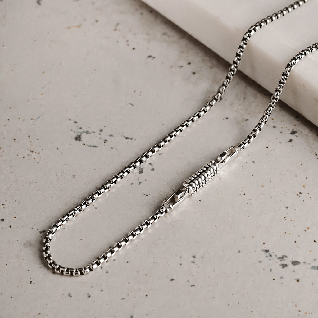A silver chain on a table.