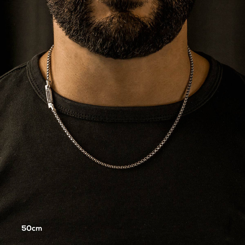 Un homme barbu portant un collier chaîne boîte « Kamal » en argent sterling de 50 cm pour homme.
