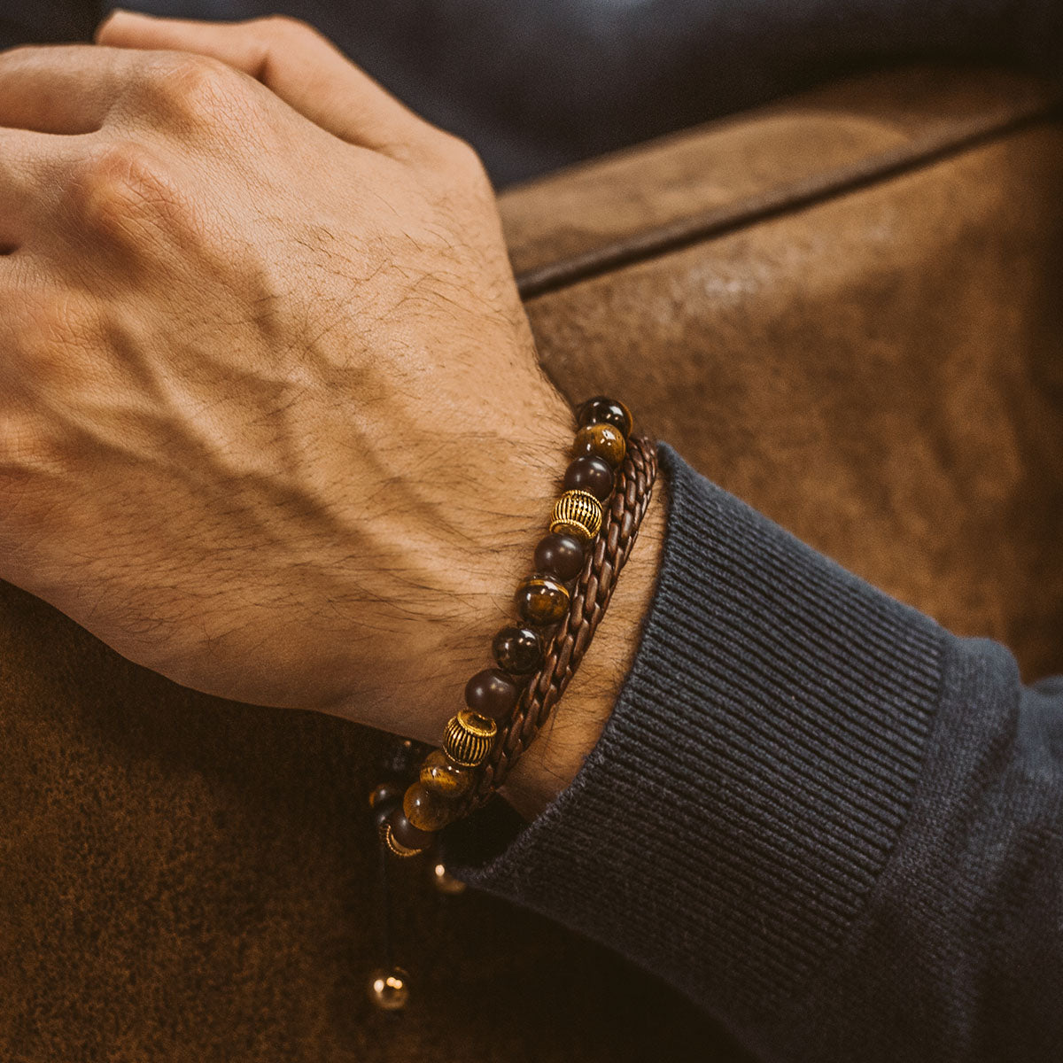 A man wearing a Kaliq - Adjustable Tiger Eye Beaded Bracelet in Gold 8mm.