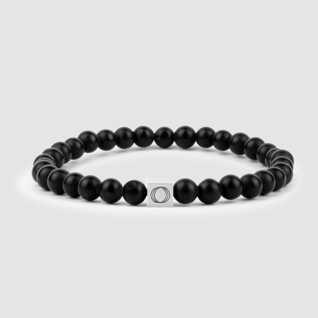 A Aswad - Bracelet de perles noir mat 6 mm avec une breloque en argent, orné d'une pierre d'onyx exquise.