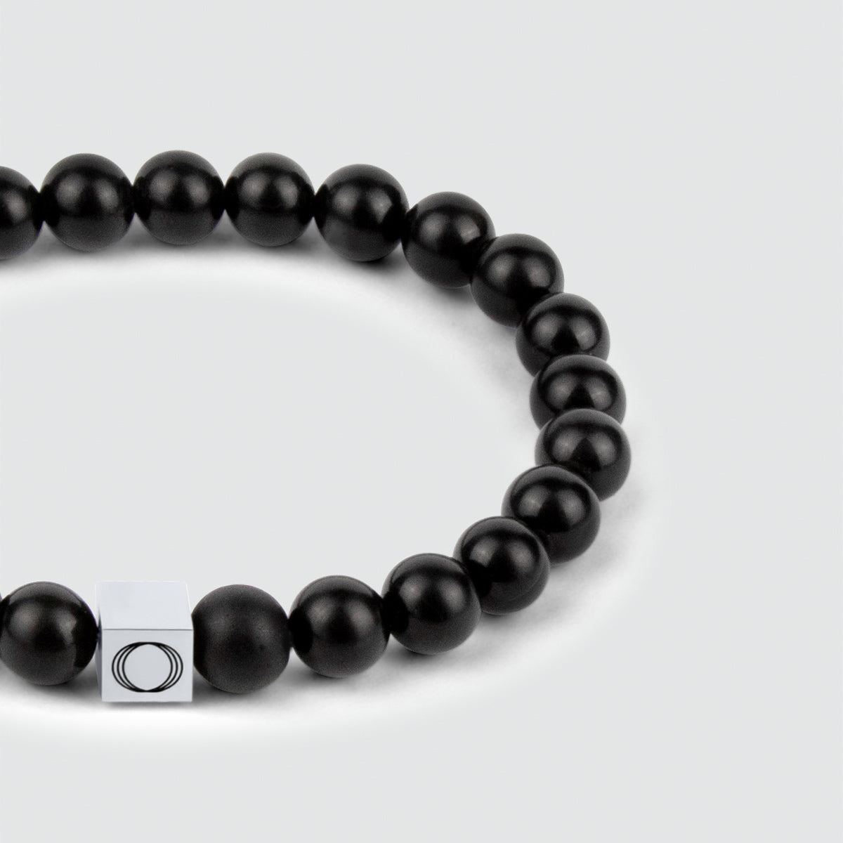 Een strakke Aswad - Mat Zwarte Kralen Armband 6mm met een zilveren sluiting.