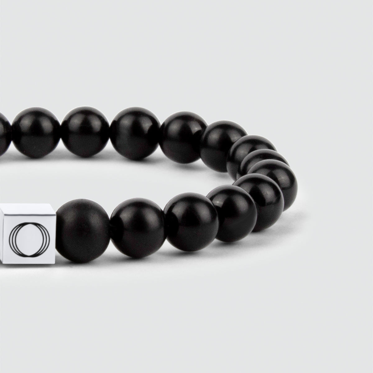 Een slanke Aswad - Mat Zwarte Kralen Armband 8mm met een zilveren sluiting.