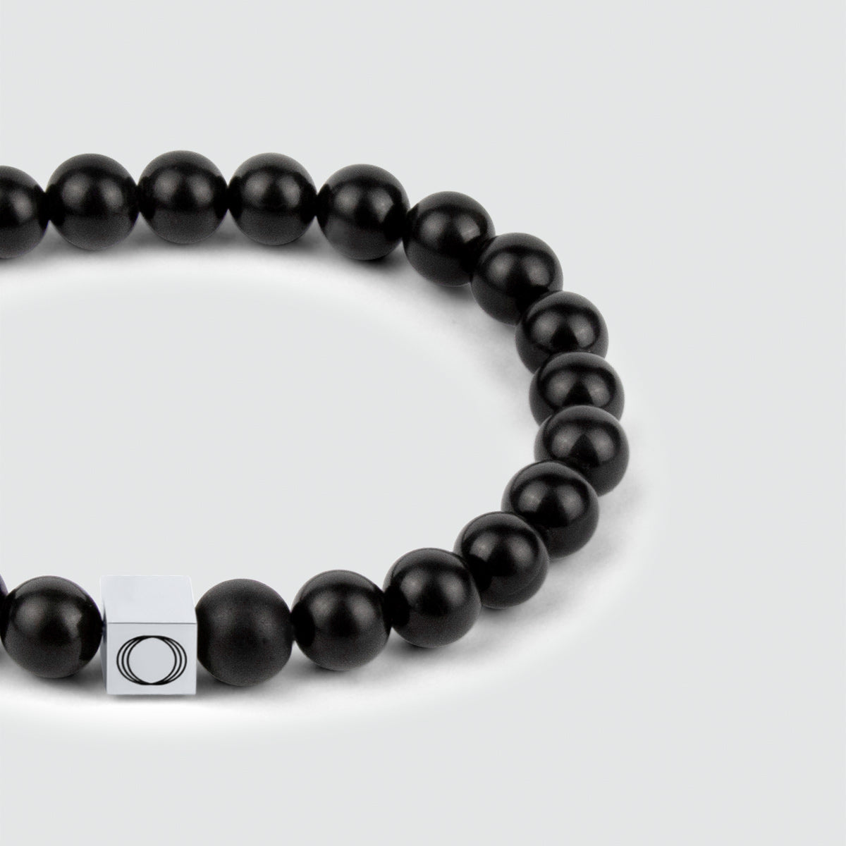 Een Aswad - Mat Zwarte Kralen Armband van 8mm met een zilveren sluiting, die de betoverende schoonheid van de onyx laat zien.