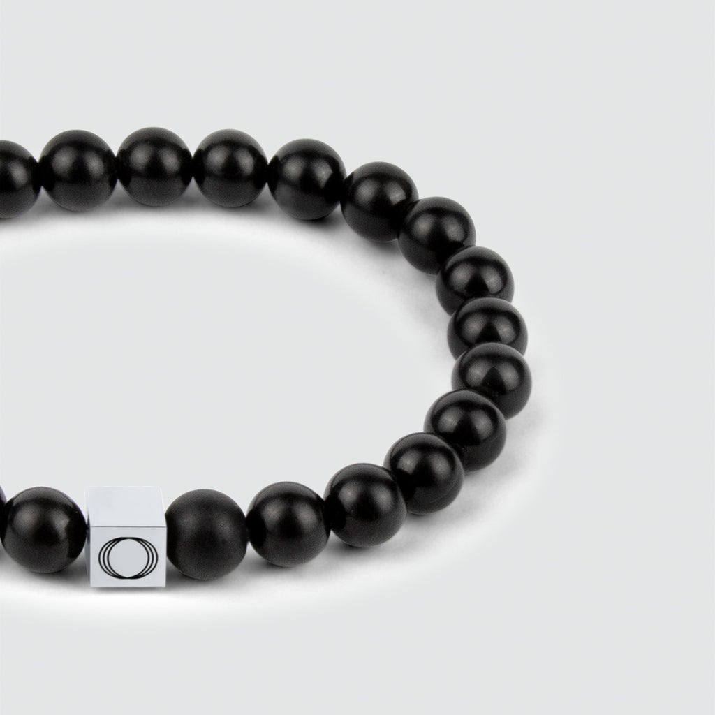 Un bracelet en perles Aswad - noir mat 8 mm avec un fermoir en argent, mettant en valeur la beauté envoûtante de la pierre d'onyx.