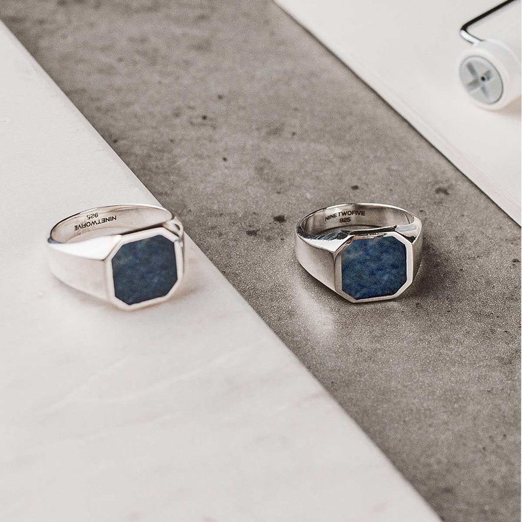 A pair of silver rings with a blue stone.