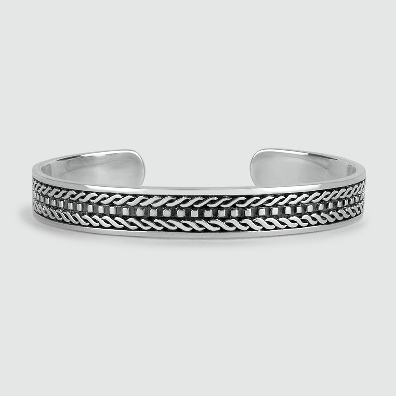 Vooraanzicht van de Fariq-bangle, vervaardigd uit geoxideerd sterlingzilver met een gevlochten patroon, ontworpen door Ninetwofive.
