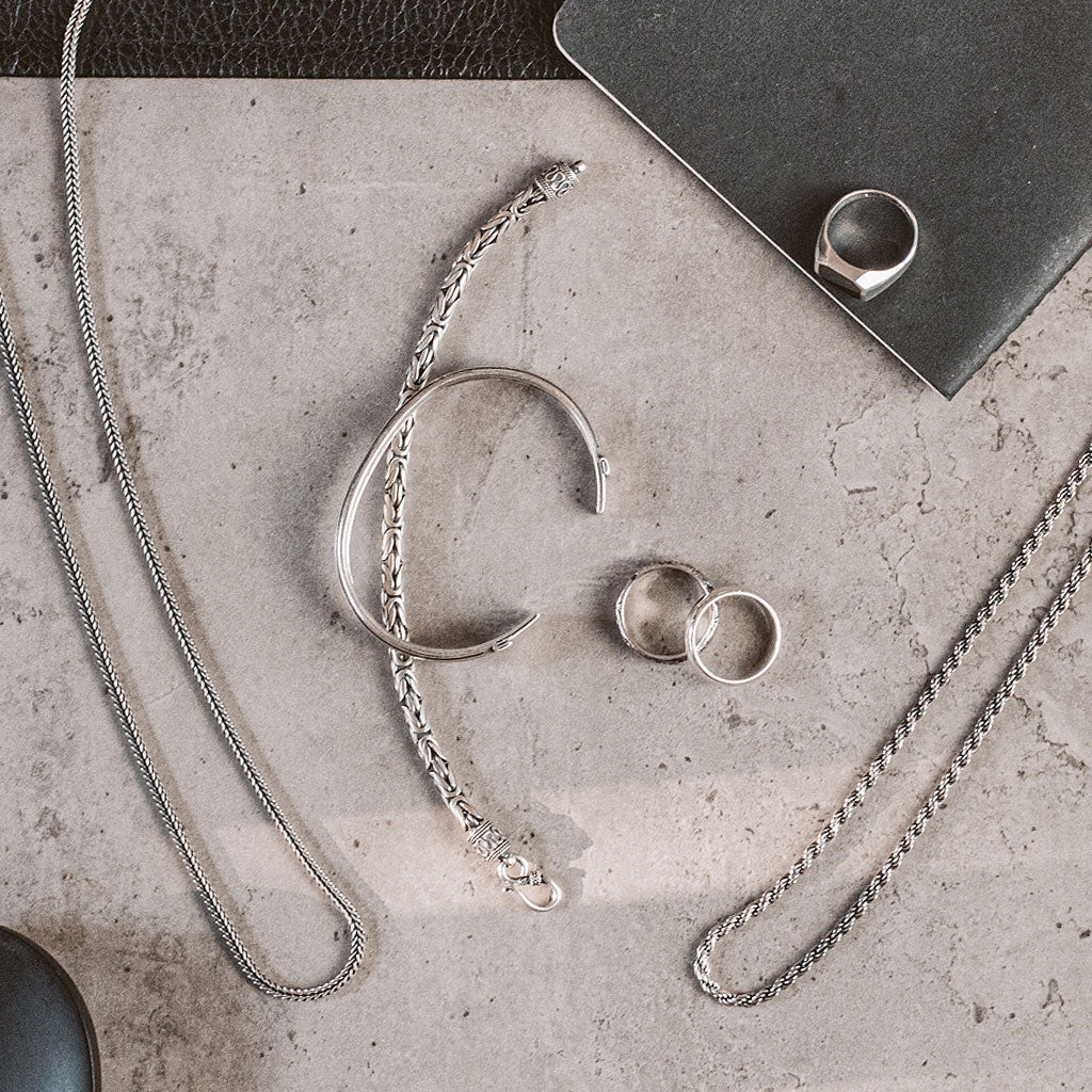 A collection of silver jewelry on a table.